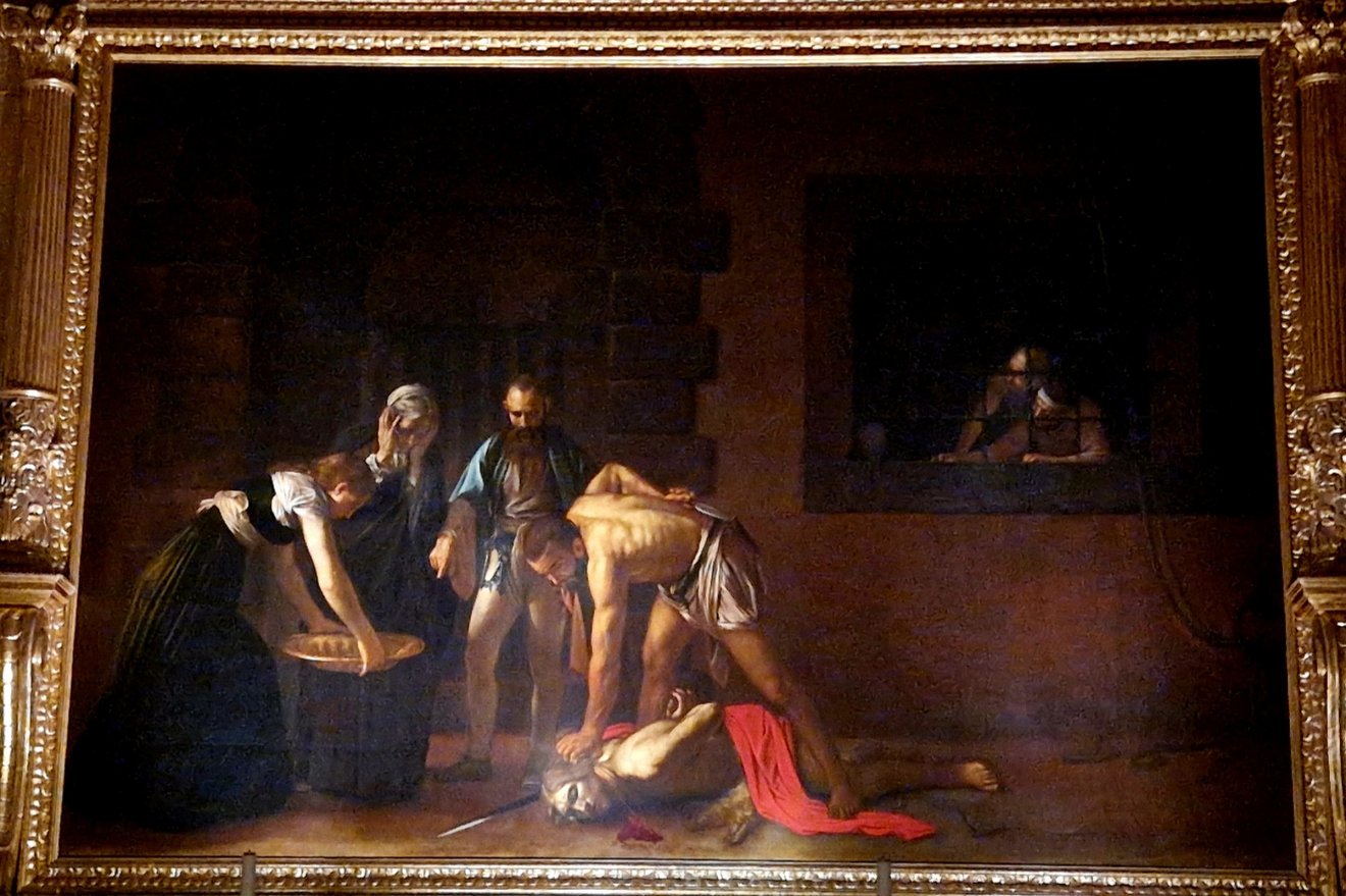 Caravaggio 1607 júliusa és 1608 októbere között élt Máltán, ahol – bár vérdíj volt kitűzve a fejére – a nagymester udvari festője lett. A Keresztelő Szent János lefejezése (1608) az egyetlen aláírt műve