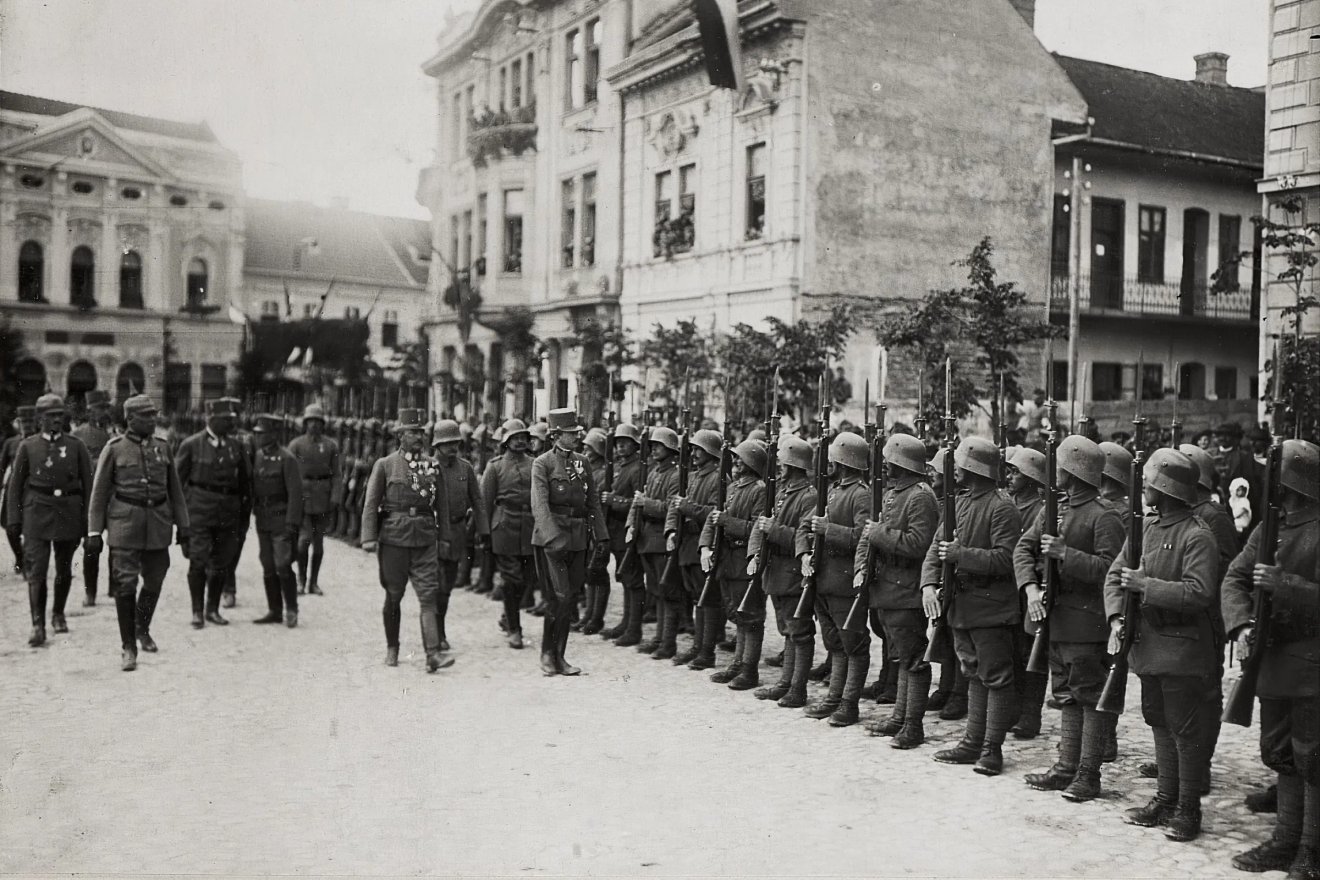 IV. Károly magyar király Kézdivásárhely főterén (1917), tőle balra Friedrich von Gerok tábornok. A háttérben balra Kupán József örmény származású kereskedő 1899-ben felépített háza, jobbra a Vigadó