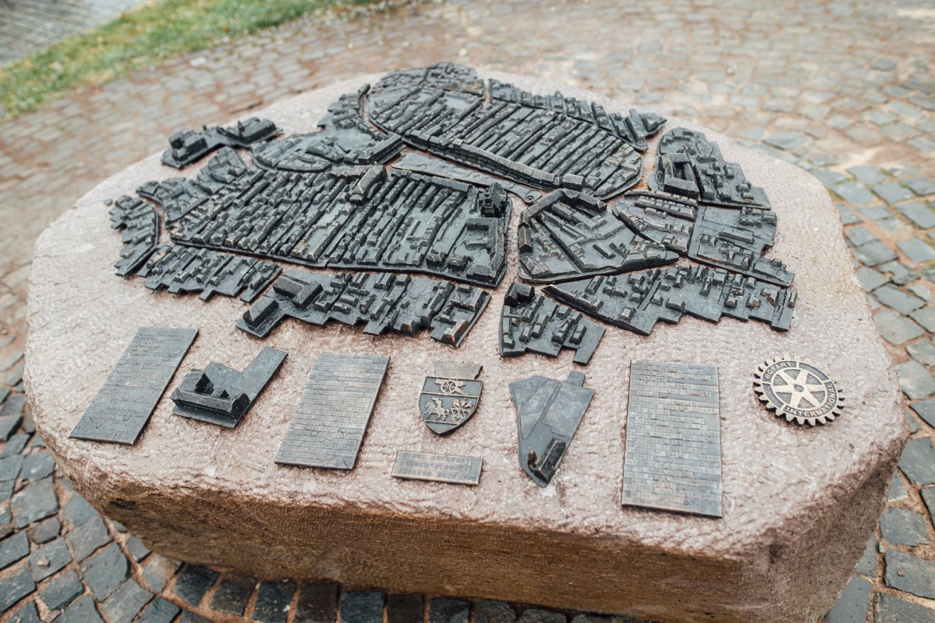 A Kovács Áron építész által tervezett, előzetesen gipszből megformázott bronzmakett egy faragottkőszikla-talapzaton kapott helyet