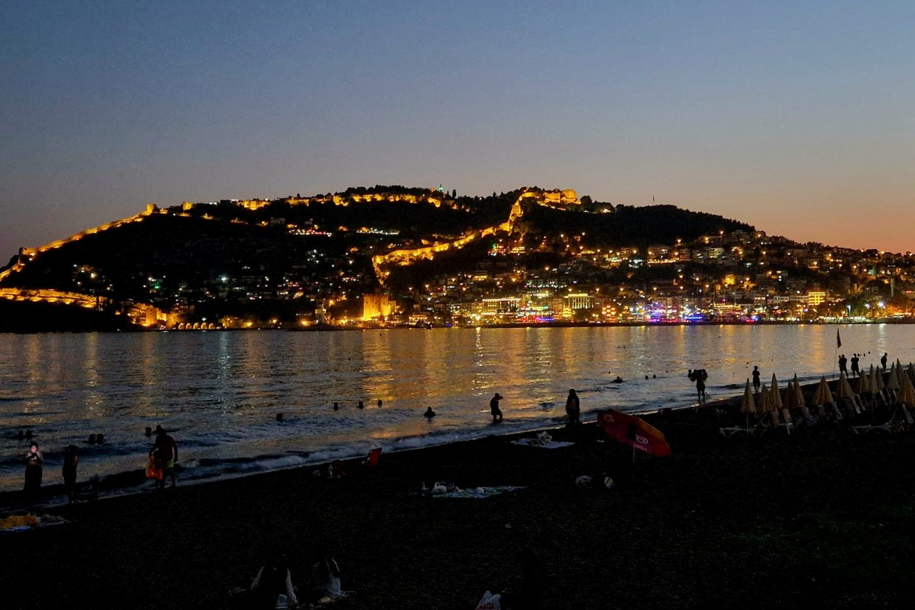 A vár esti megvilágításban. Alanya másik jelképe, a vörös torony is kivehető rajta