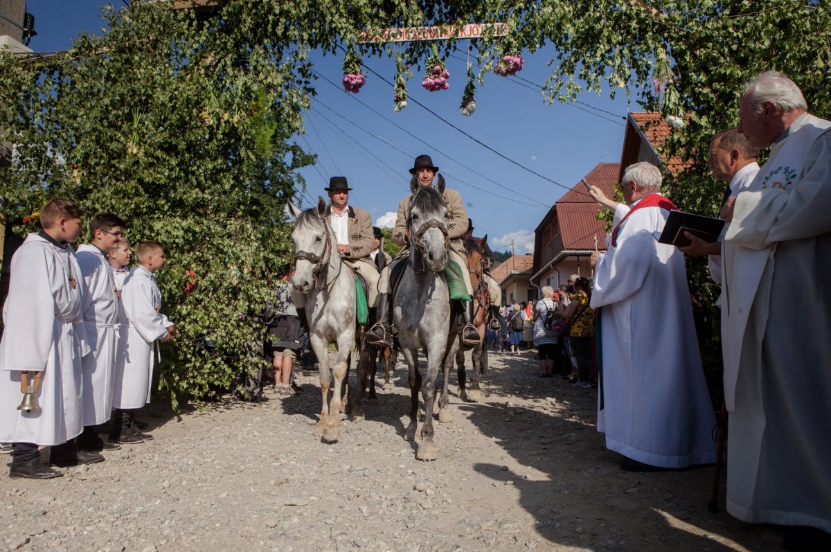 A zetelaki plébános megáldja a hazatérő zarándokokat a tiszteletükre készített, szimbolikus kapu alatt. Innen közösen, imádkozva és énekelve vonulnak a templomba •  Fotó: Erdély Bálint Előd