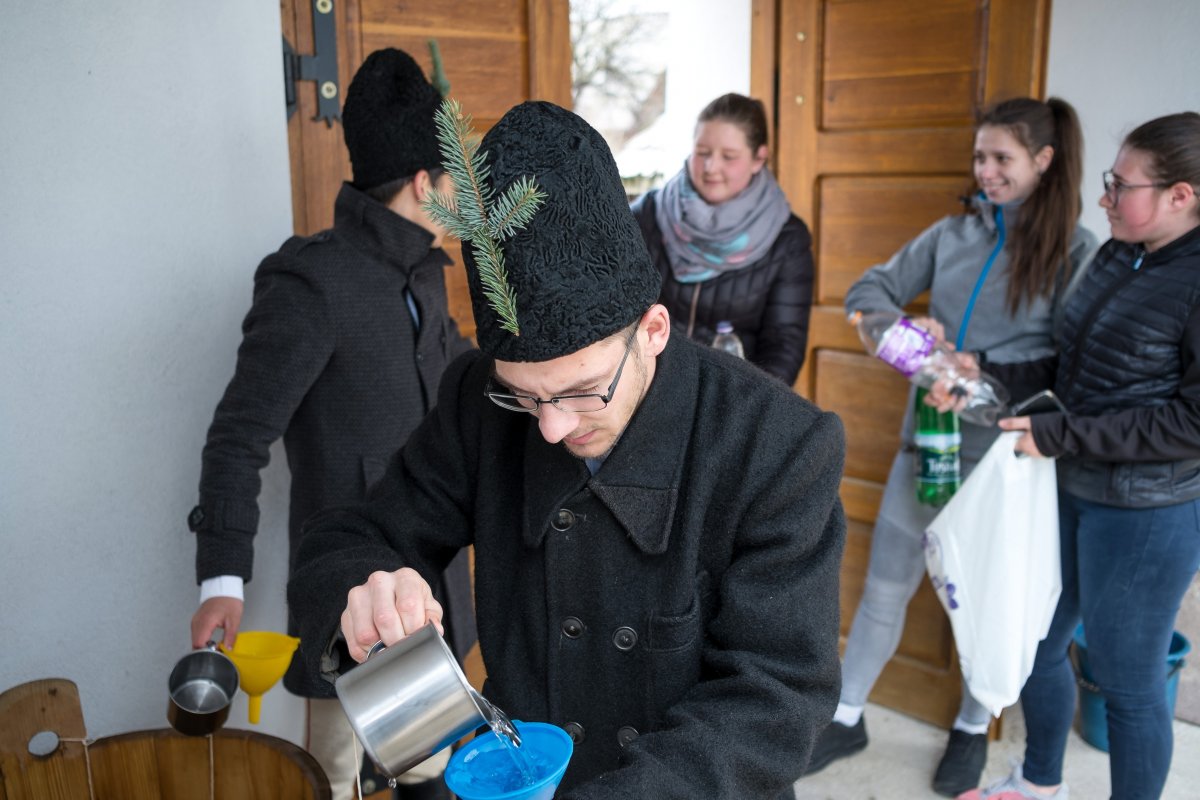 Csíkszentdomokosi fiatalok szentelt vizet töltenek a palackokba a vízszentelést követően •  Fotó: Veres Nándor/MTI