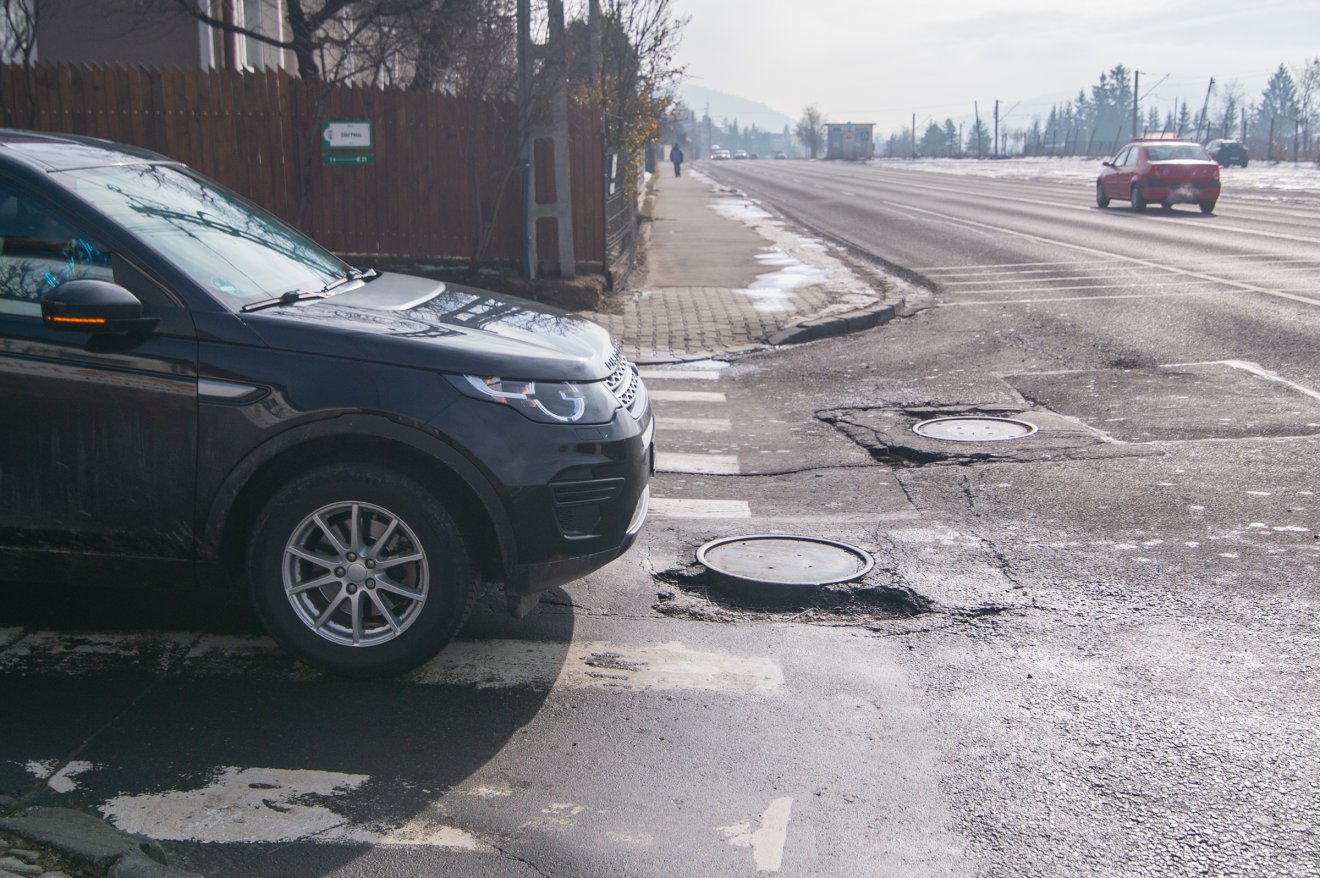 Döccenős a kijutás a Brassói útra a Zöld Péter utcából. Itt is kigödrösödött az út a csatornafedő körül &bullet;  Fotó: Borbély Fanni