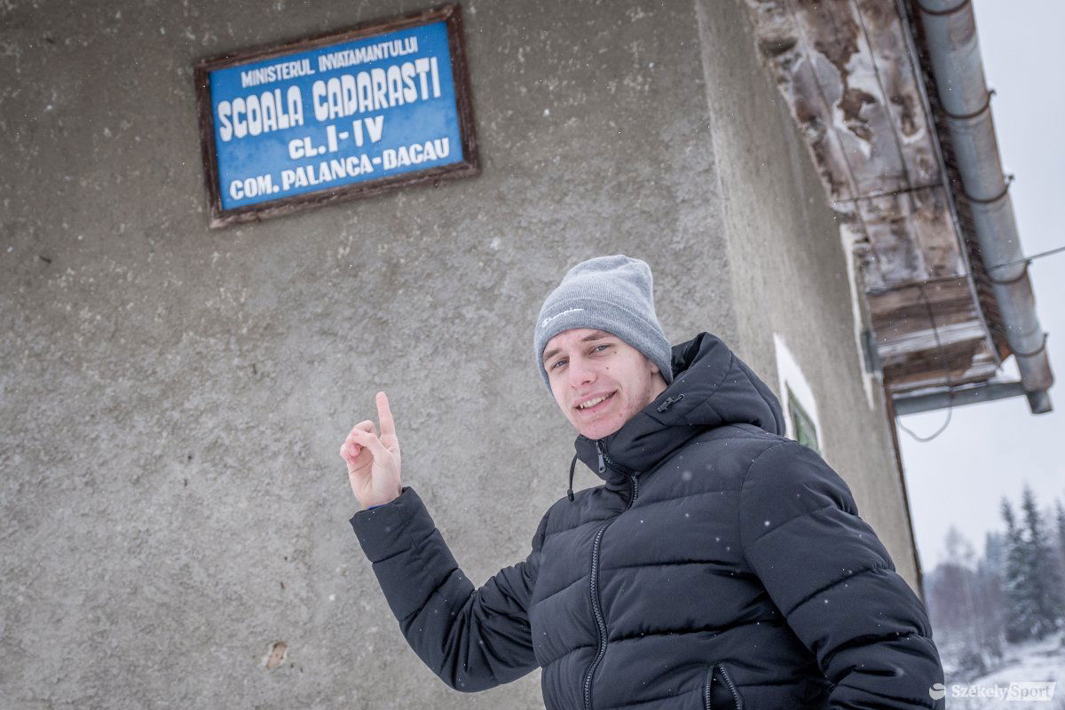 Marius Corbu az egykori, már 20 éve nem működő magyarcsügési iskola előtt. Ennek udvarán fociznak a helybeli gyerekek •  Fotó: Pinti Attila