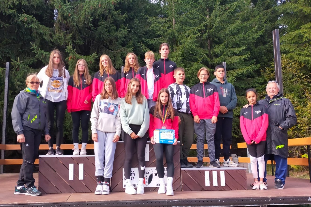 A Csíkszeredai ISK gyermek korosztályú, haladó biatloncsapata. Balról Gecse Izabella, jobbról pedig Péter Árpád edzők •  Fotó: Román Sí- és Biatlon-szövetség (FRSB)