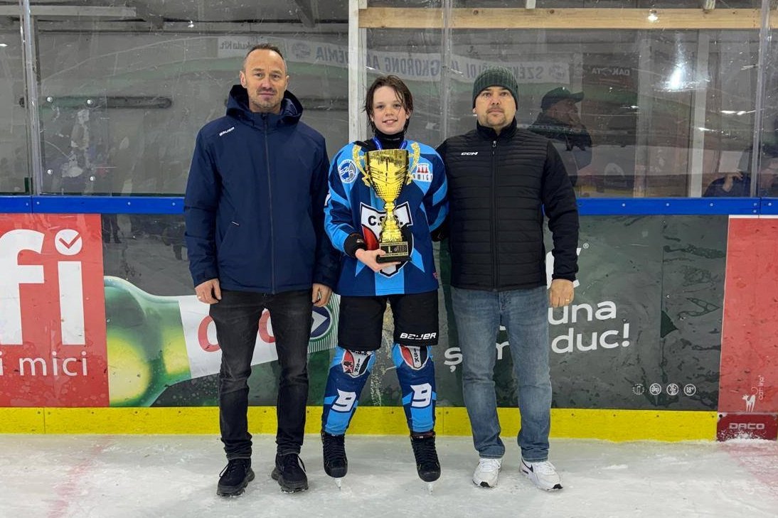 Botár Zsombor (középen, Csíkszeredai ISK) a bajnoki serleggel. Balról Moldován Ervin, jobbról pedig ifj. Antal Előd –  szakszövetség vezetőségi tagjai &bullet;  Fotó: Román Jégkorong-szövetség (FRHG)