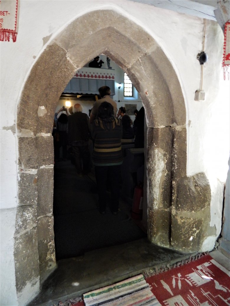 Istentisztelet a templomban. Csúcsíves, hornyolt déli kapuzata gótikus stílusú •  Fotó: Demján László