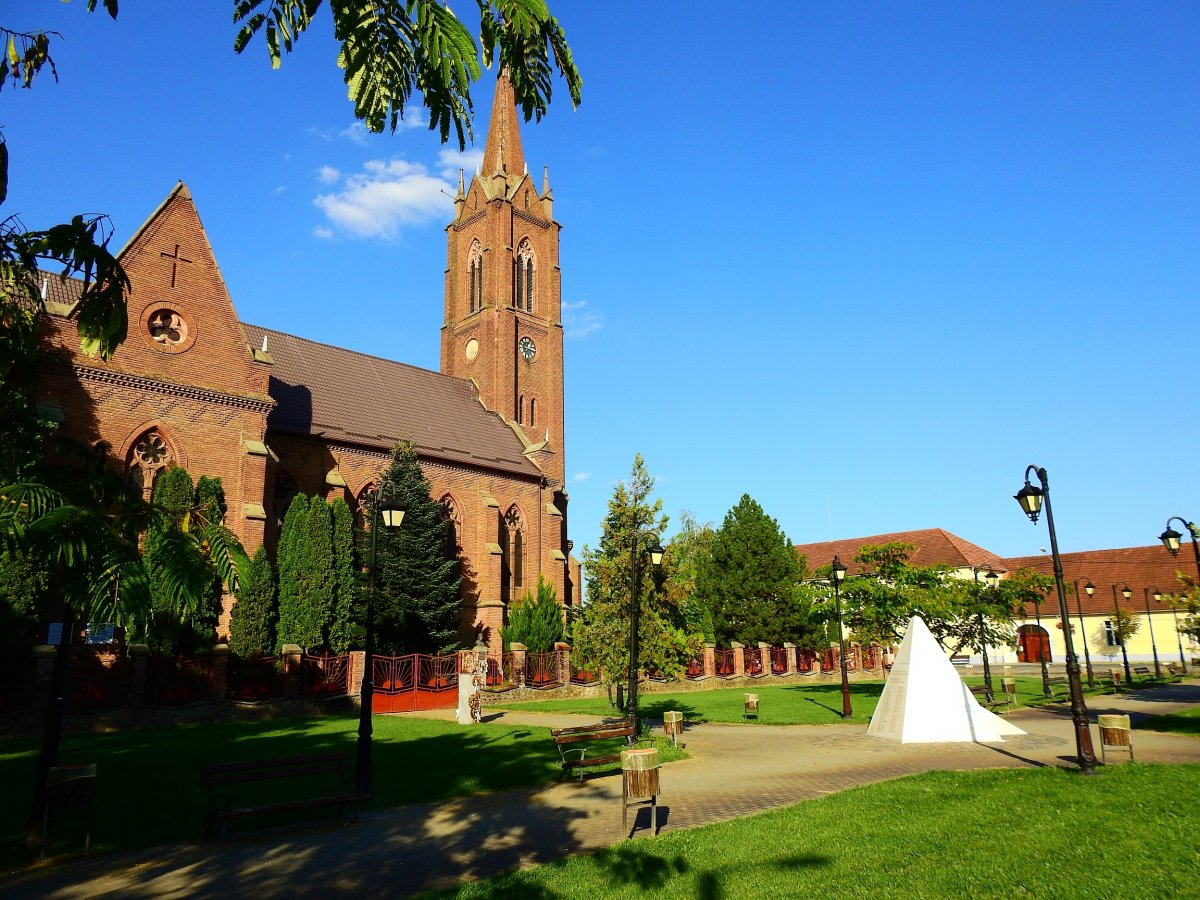 Pécska főtere a római katolikus templommal. A Szentháromság parkban két magyar emlékmű is áll • Fotó: Makkay József