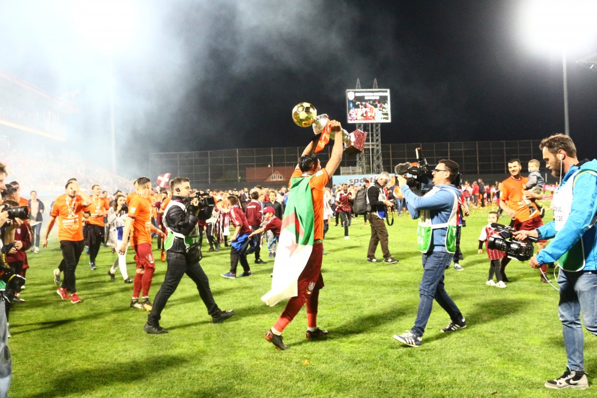 Öröm a gyepen. Billel Omrani, a CFR csatára algériai zászlóba burkolózva viszi a serleget &bullet;  Fotó: Riti József Attila