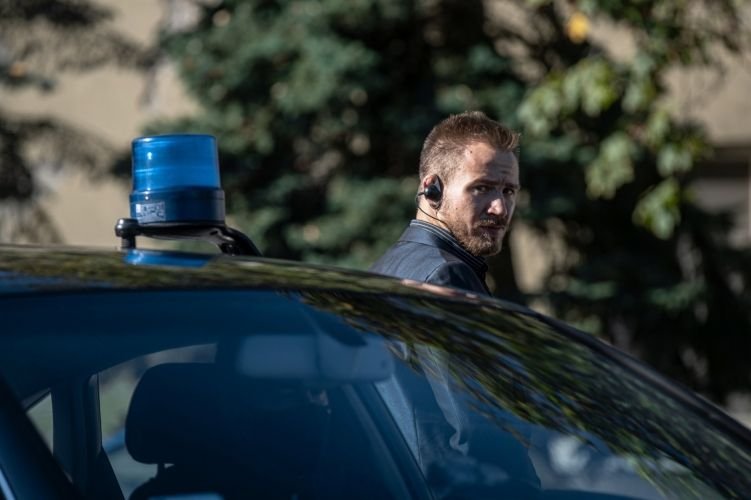 A védenc személy kocsijának biztonságát ellátó testőr •  Fotó: Police.hu