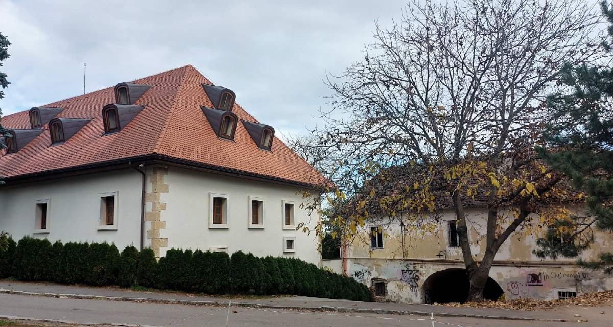 Így néz ki a szépen, illetve sehogy sem őrzött múlt egymás mellett. Balra egy Habsburg-hadiépület (ha jól emlékszem, élelmiszerraktár), amelyet remekül felújítottak. Ma egy magáncég bérli. Jobbra a Fellegvár fennmaradt három kapujának egyike, amelyen át le lehet sétálni a Szamos-partra. Feltehetőleg jogi akadályok miatt nem lehetett felújítani, borzalmasan is néz ki. A felül látszó épületben időnként hajléktalanok tanyáznak, most is be lehet hatolni... nem szép, nem is illatos látvány fogadja, aki bemerészkedik. 
