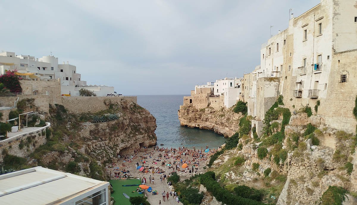 Polignano a Mare sziklafalak közé ékelődő híres strandja a Borbonico hídról. •  Fotó: Fall Sándor