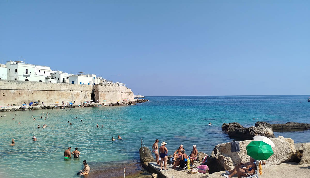 Strandolás a várfal tövében, Monopoli. •  Fotó: Fall Sándor