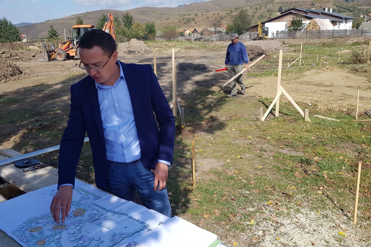 A polgármester a park terveit mutatja, a háttérben már zajlik a kivitelezés •  Fotó: Gergely Imre