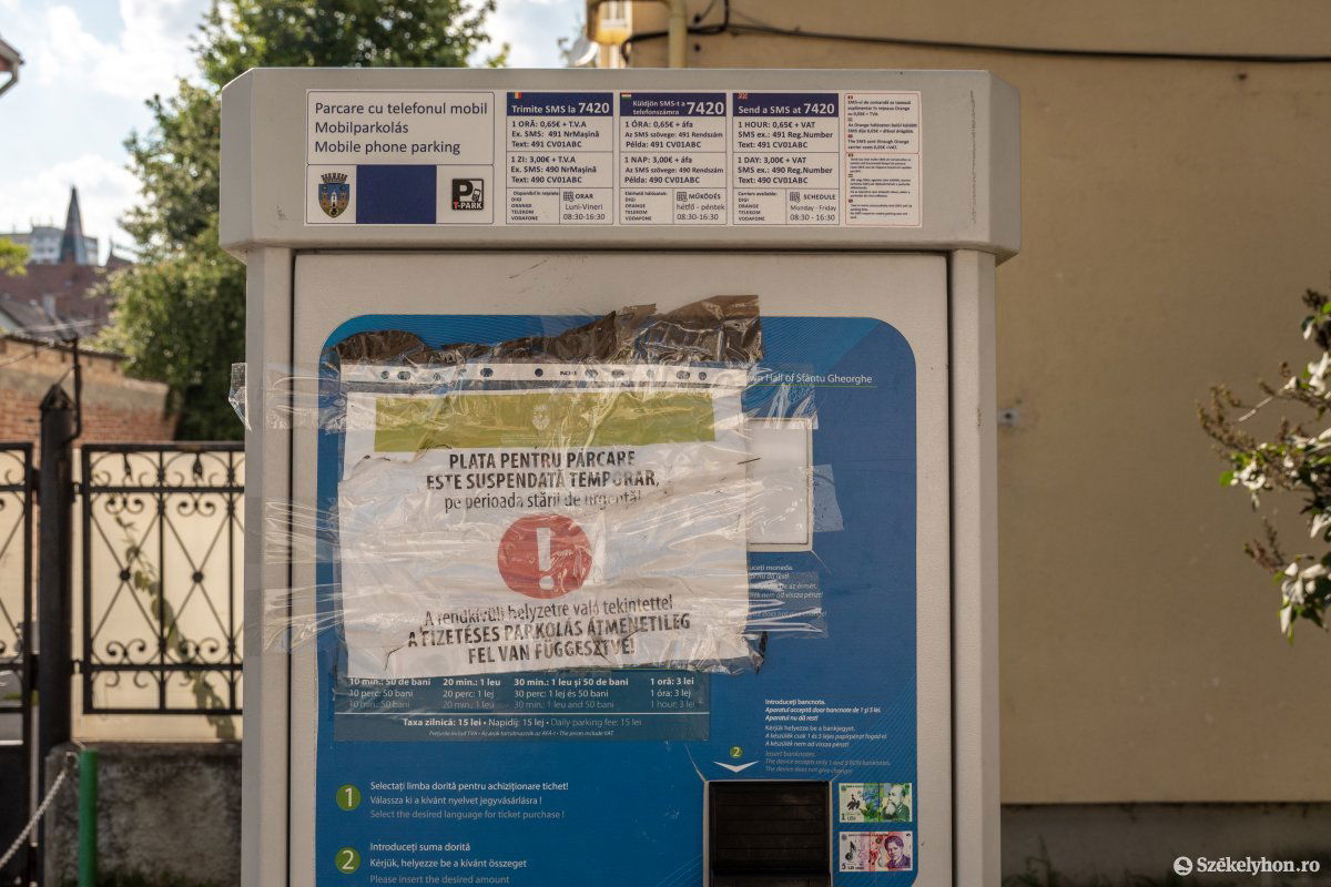 Lekerülnek a fizetéses parkolás felfüggesztéséről tájékoztató lapok az automatákról •  Fotó: Pinti Attila