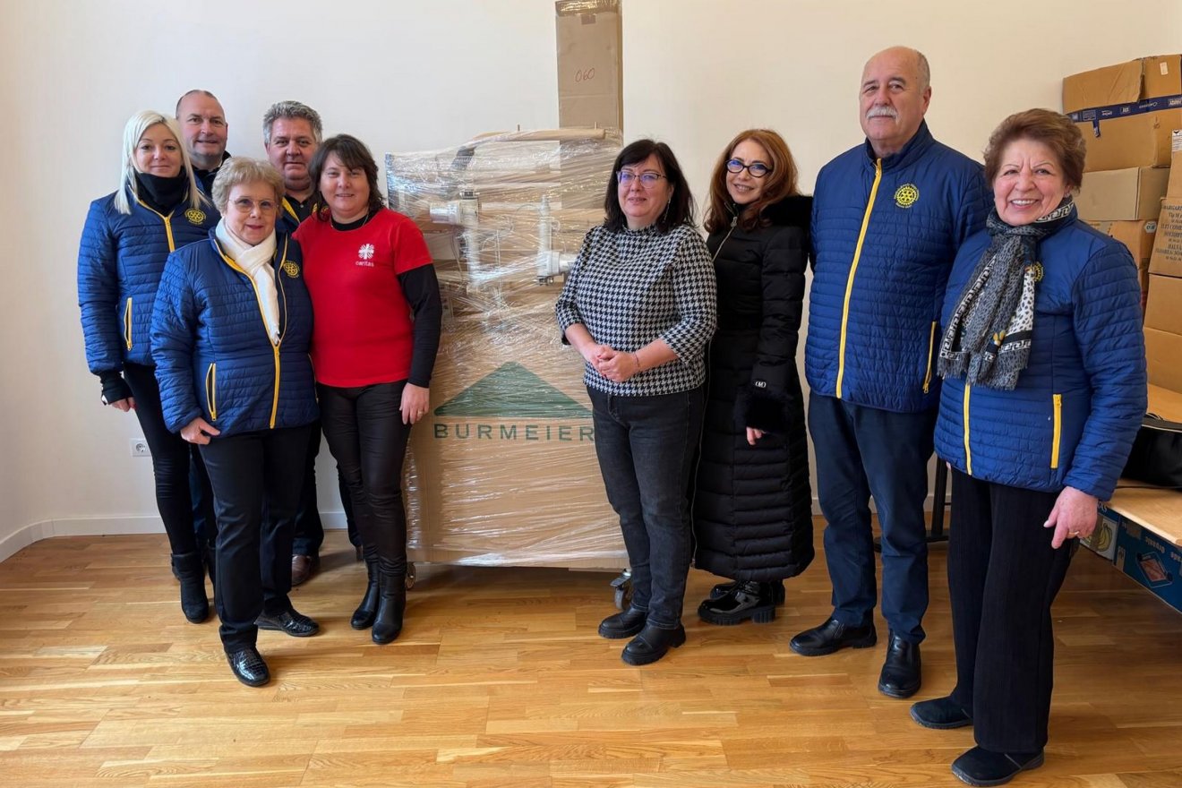Istók Katalin (pirosban) és az adományozók (kék kabátban, a Rotary Vlub képviseletében) •  Fotó: Kézdivásárhelyi Caritas