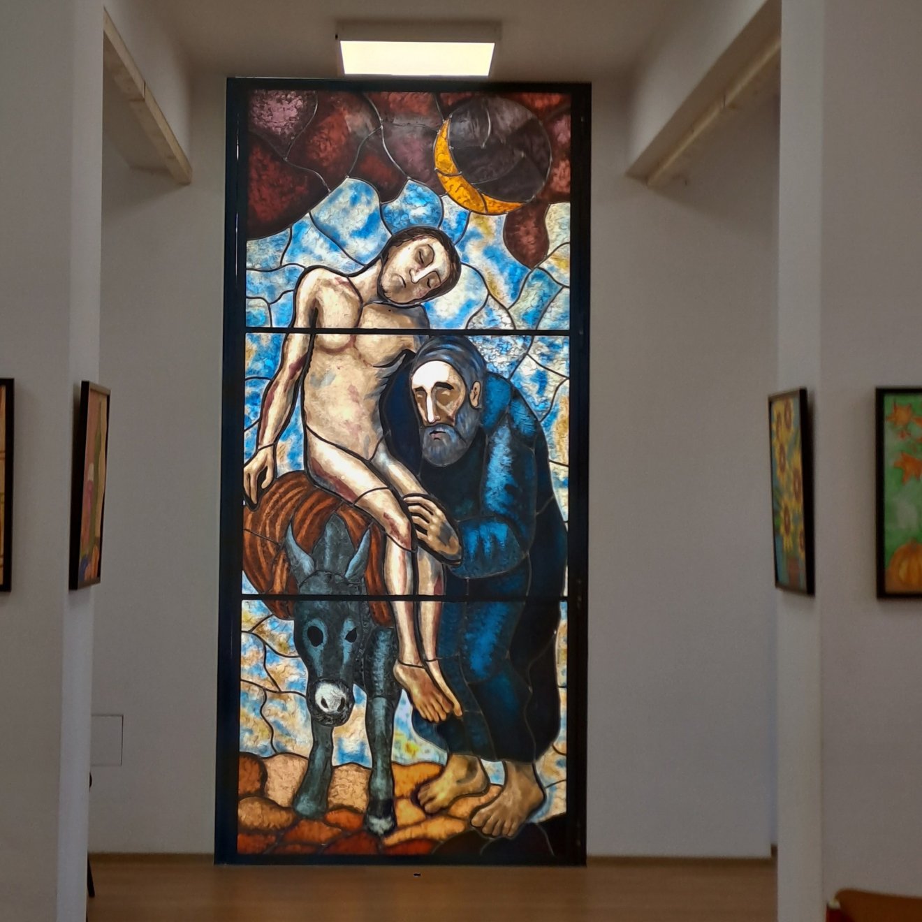 Makkai András és Eszter az irgalmas szamaritánust ábrázoló vitráliuma ékesíti az épület rendezvénytermét •  Fotó: Torma Vera