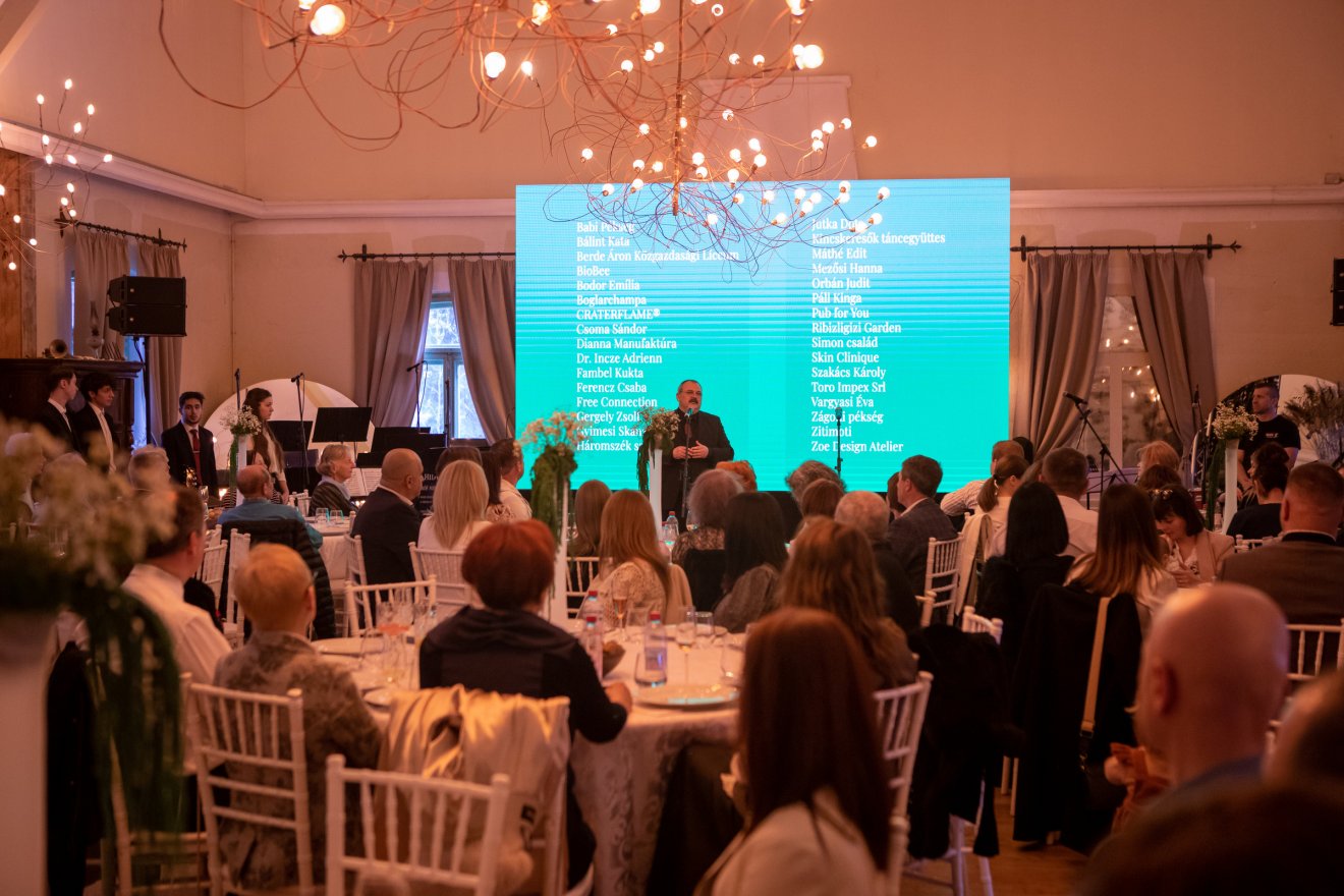 A támogatók hosszú sora a képernyőn, Makkai Péter, a Diakónia sepsiszentgyörgyi igazgatója szól a jelenlevőkhöz &bullet;  Fotó: Opra Gergely Szilárd