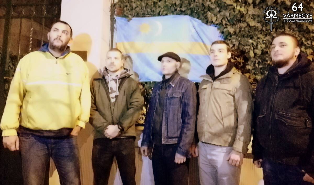 A HVIM vezetői pózolnak a székely zászlóval letakart tábla előtt •  Fotó: HVIM