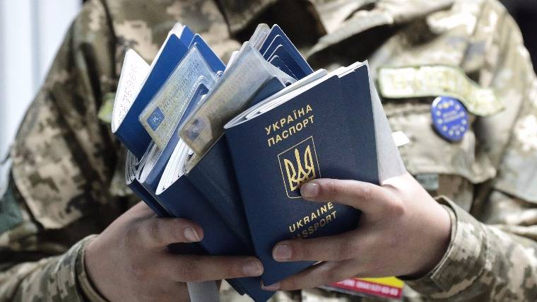 Útleveleket ellenőriz egy ukrán határőr az ukrán–lengyel határ Rava-Ruska átkelőhelyén •  Fotó: MTI/EPA