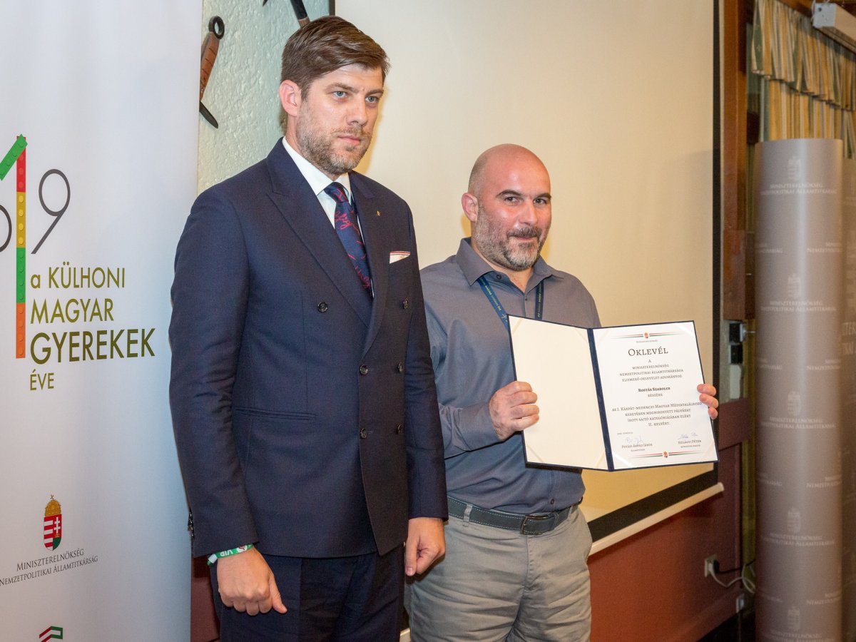 Szilágyi Péter miniszteri biztos (balra) adta át az írott sajtó kategória második helyéért járó oklevelet Rostás Szabolcsnak, a Krónika vezető szerkesztőjének &bullet;  Fotó: Nemzetpolitikai Államtitkárság