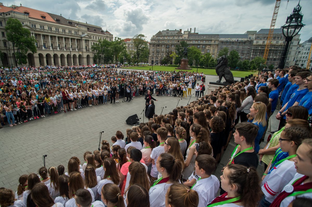 Szarka Tamás Kossuth-díjas énekes, zenész, zeneszerző (középen) és diákok éneklik a Kézfogás című dalt, a magyar összetartozás himnuszát a nemzeti összetartozás napján rendezett ünnepségen a Parlament előtt • Fotó: MTI/Balogh Zoltán