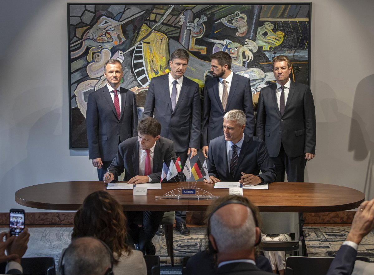 Bruno Even, az Airbus Helicopters vezérigazgatója és Kun Miklós, a Nemzeti Légiipari Projekt Kft. ügyvezető igazgatója (az asztalnál) a repülőgépalkatrész-gyártó vegyesvállalat létrehozásáról szóló dokumentumok aláírásán •  Fotó: MTI/Szigetváry Zsolt