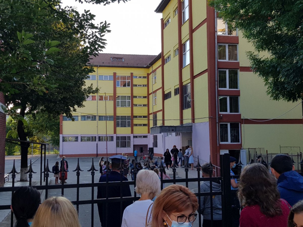 A szülők a kerítésen kívül, a diákok az iskola udvarán sorakoznak a bejáratnál •  Fotó: Rostás Szabolcs