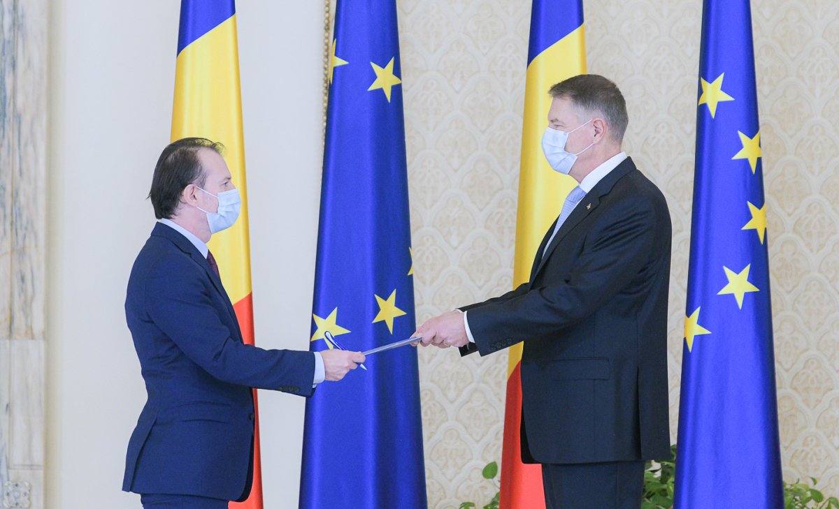 Klaus Iohannis államfő (jobbra) átnyújtja a miniszterelnöknek a kinevezéséről szóló rendeletet •  Fotó: Presidency.ro