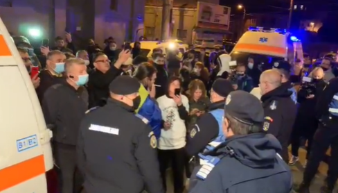 Tüntetők és csendőrök gyűrűjében hozták ki, és tették mentő- vagy személyautóba a betegeket Bukarestben •  Fotó: Videófelvétel