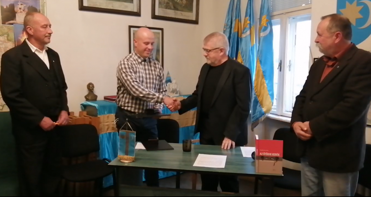Izsák Balázs SZNT-elnök (jobbról a második) átnyújtja a kitüntetést Szőcs Zoltánnak •  Fotó: Videófelvétel