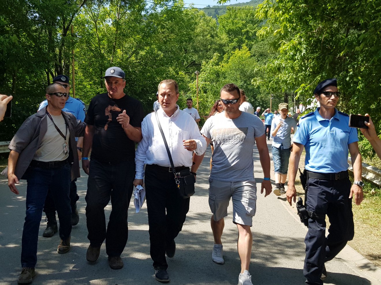 Mihai Tîrnoveanut (középen) és társát vezetik ki a tusnádfürdői kemping területéről a Tusványos tavalyi kiadásán •  Fotó: Rostás Szabolcs