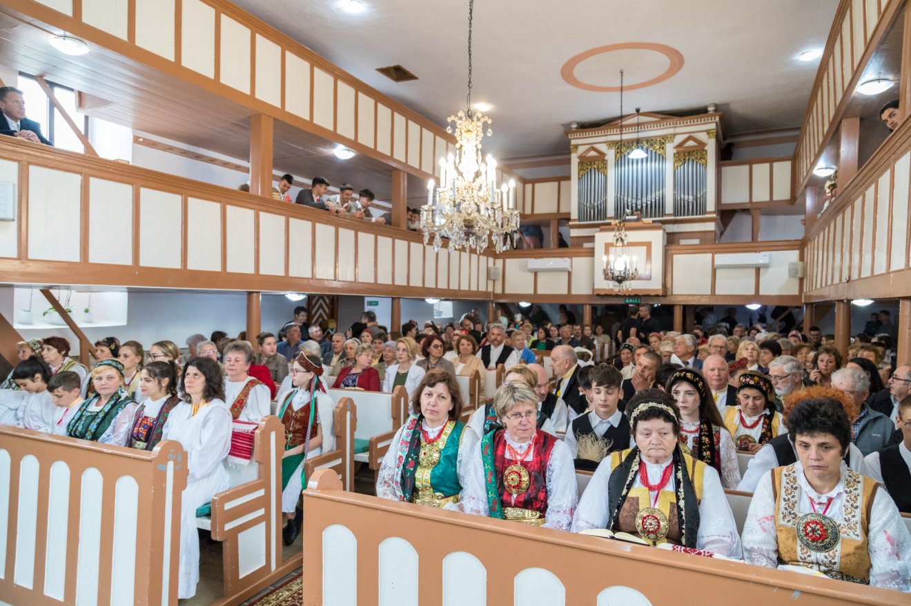 Csángó népviseletbe öltözött zarándokok a bácsfalui evangélikus templomban •  Fotó: Evangélikus.ro