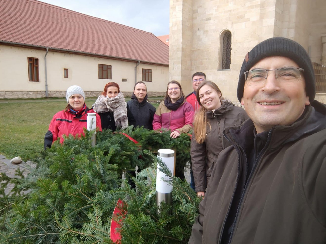 Kerekes László, a Gyulafehérvári főegyházmegye segédpüspöke (jobbról) és az adventi koszorút készítő csapat •  Fotó: Gyulafehérvári Római Katolikus Érsekség/Facebook