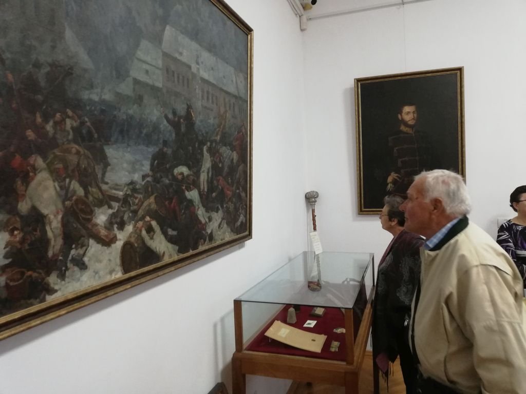 Miklóssy Gábor Utcai harc Aradon című festményét tekintik meg érdeklődők az Ereklyemúzeumban (a háttérben a falon Kaufmann Izidor portréja Asztalos Sándor honvéd főhadnagyról) •  Fotó: Pataky Lehel Zsolt