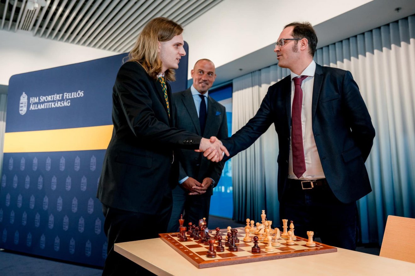 Rapport Richárd és Lékó Péter kezet ráz a visszatérésre és a a budapesti sakkolimpián való szereplésre; a háttérben Schmidt Ádám sportért felelős államtitkár •  Fotó: Dr. Schmidt Ádám/Facebook
