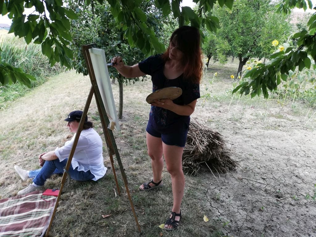 Siska-Szabó Hajnalka aradi festőművész a Nagyzeréndi Nemzetközi Alkotótábor résztvevőit minden évben elhozza egy napra a tájházba •  Fotó: Pataky Lehel Zsolt