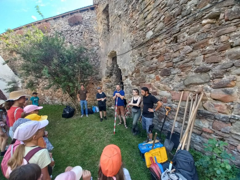 A régészeti táborban részt vevő gyerekek „belekóstolhattak” a háromszéki Árkos unitárius templomváránál zajló ásatások folyamatába •  Fotó: Tamás Sándor/Facebook