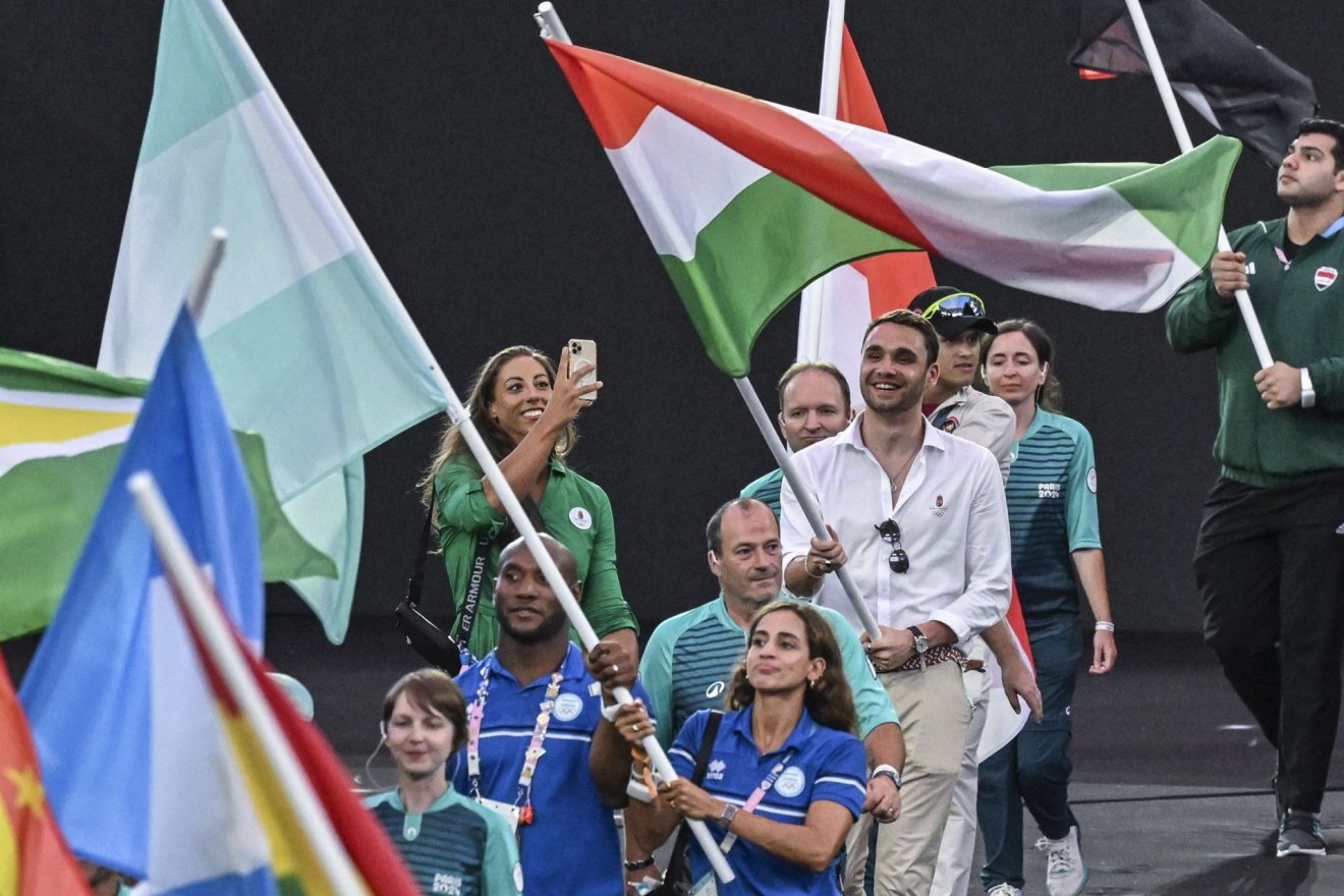 Milák Kristóf kétszeres olimpiai bajnok úszó viszi a magyar zászlót, mellette Csipes Tamara kétszeres olimpiai bajnok kajakozó a 2024-es párizsi nyári olimpia záróünnepségén a Stade de France-ban •  Fotó: MTI/Czeglédi Zsolt