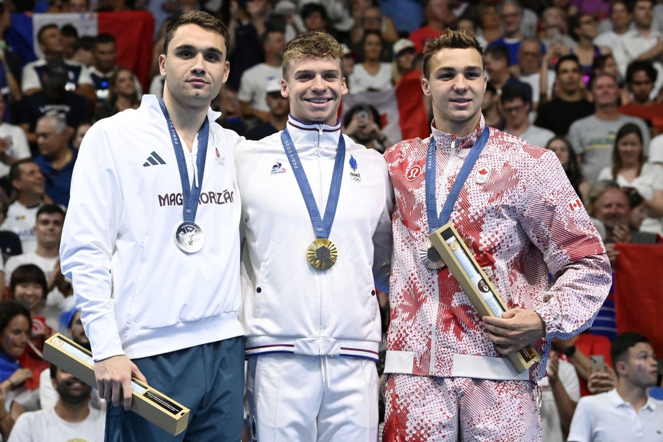 Az aranyérmes francia Léon Marchand, az ezüstérmes Milák Kristóf és a bronzérmes kanadai Ilya Kharun a férfi 200 méteres pillangóúszás eredményhirdetésén •  Fotó: MTI/Kovács Tamás
