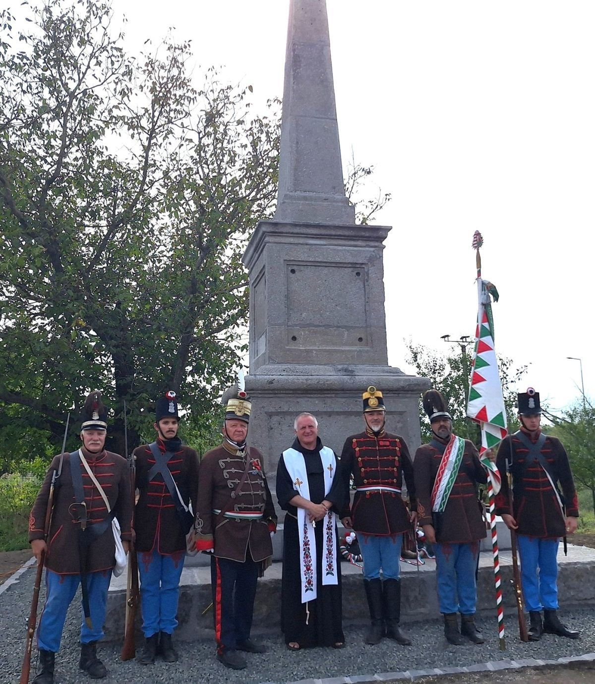 Böjte Csaba ferences szerzetes a Budai 2-ik Honvédzászlóalj tagjai közül néhánnyal az obeliszk előtt •  Fotó: Facebook/Budai 2-ik Honvédzászlóalj