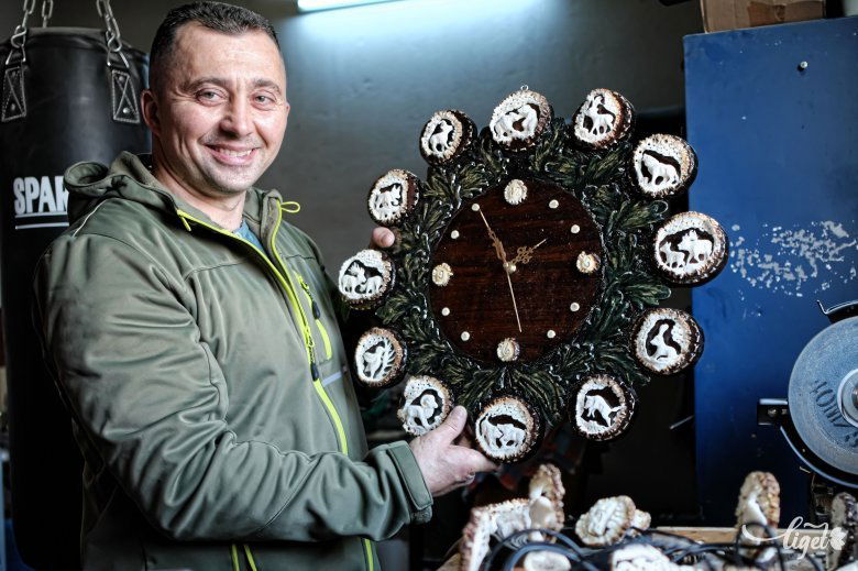 Szász Róbert Szilárd és nagy büszkesége, a tizenkét rózsás falióra •  Fotó: Veres Nándor