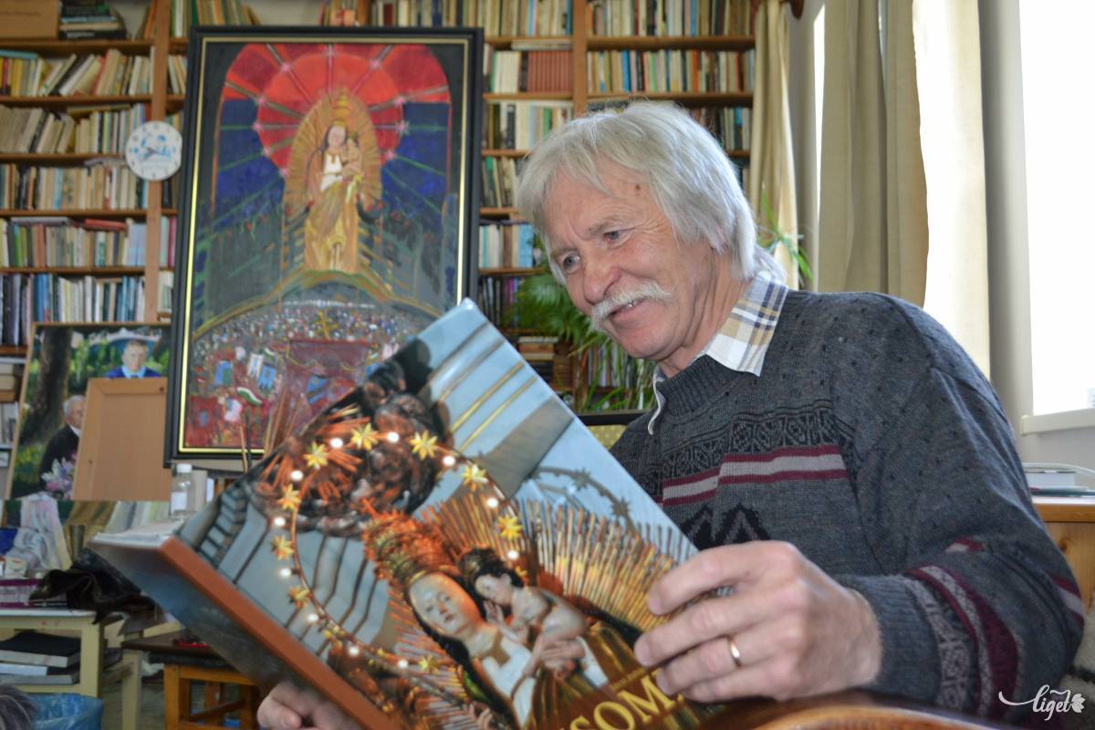 Balázs József zarándoklatvezető. Háttérben az ő alkotása a csíksomlyói Babba Máriáról 