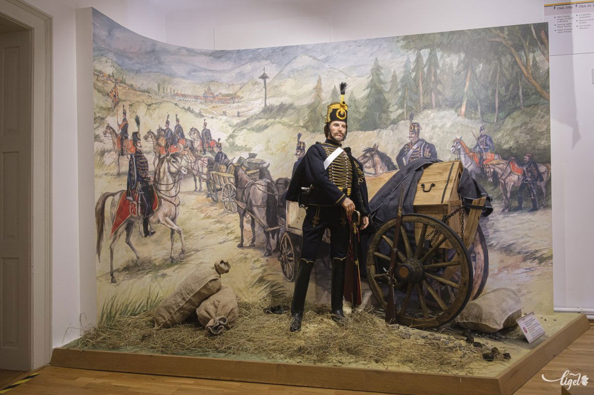 Ferencz Ignác huszárőrmester 1790-ben, amint a társaival vonulnak a Gyimesi-szorosban őrjáratozni. Háttérben a csíksomlyói régi gótikus templom Még a búcsúba is a határőrezredek ezredzenekarai kísérték fel a népet menetben •  Fotó: Veres Nándor