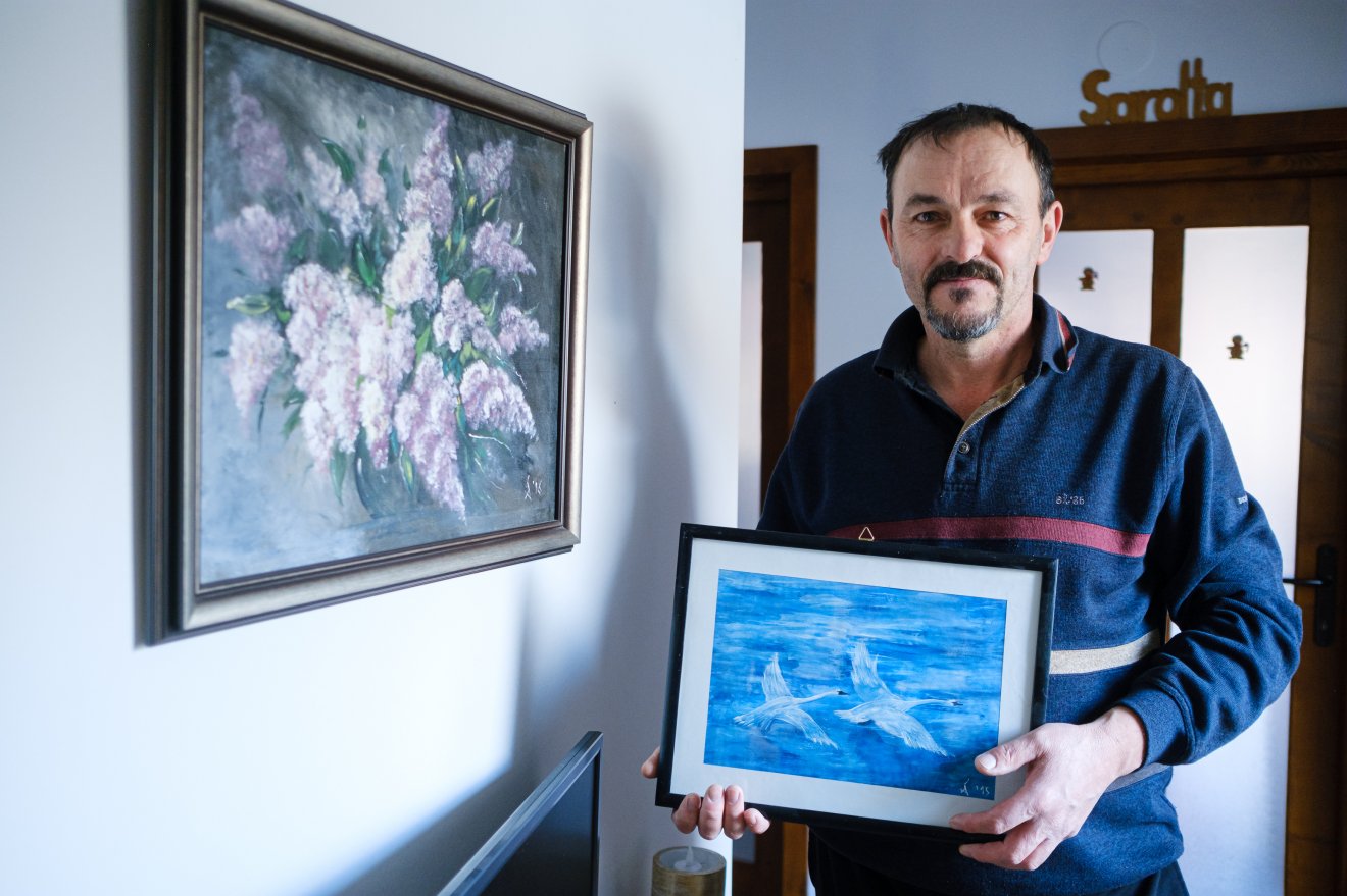 Csiszer András két festményével. A kezében levő volt az első ilyen jellegű alkotása •  Fotó: Veres Nándor