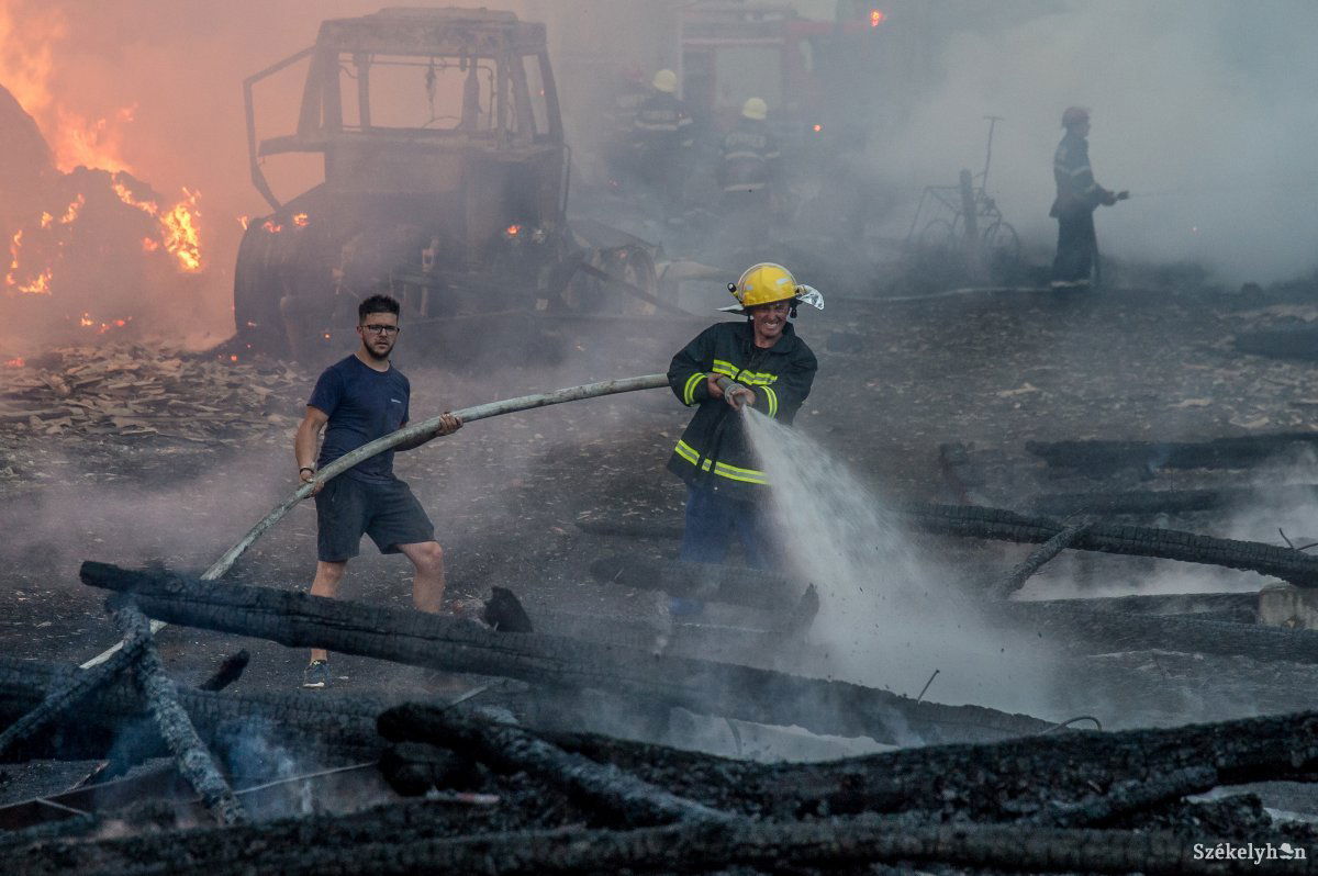 Tűzoltó és civil küzd a lángokkal egy homoródszentpáli tűzesetnél augusztus 17-én •  Fotó: Barabás Ákos