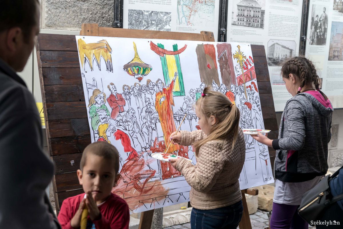 Közös alkotás készül a bütyköldében. Több kéz színezi az óriás kifestőt •  Fotó: Veres Nándor