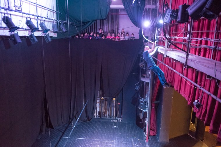 A színpaddal szemben, a nézők mögött