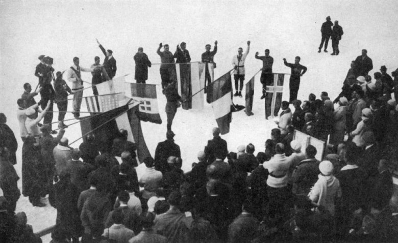A részt vevő országok zászlói a „nyitóünnepségen”, középen a francia 
Camille Mandrillon biatlonista tartja 
a rendező ország trikolórját •  Fotó: Wikimedia Commons