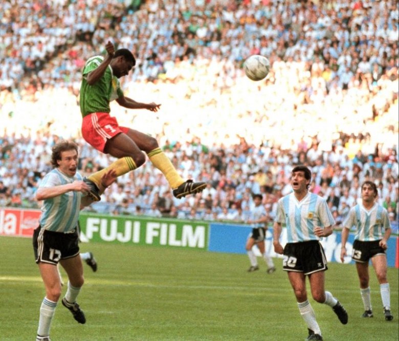 A nyitómeccsek meglepetései közül 
is a legnagyobb 1990-ben Milánóban történt: François Omam-Biyik 
(7) az argentin Sensini (17), Juan 
Simón (20) és Néstor Lorenzo (13) 
elől a kapura fejel, ezzel Kamerun 
1–0-ra legyőzte a címvédőt •  Fotó: Wikimedia Commons